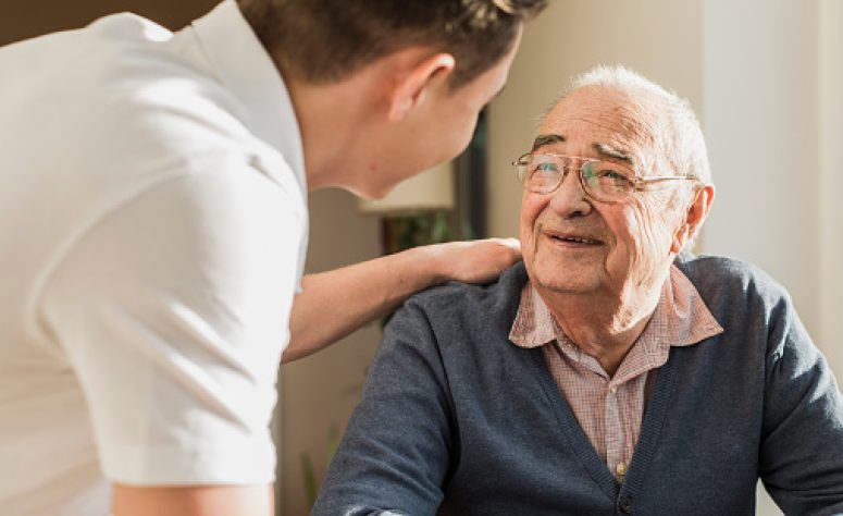 Pfleger hilft älterem Herren